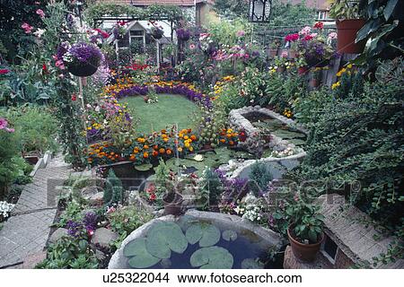 Picture - Small ponds in suburban garden with profuse colourful flowering annuals. Fotosearch