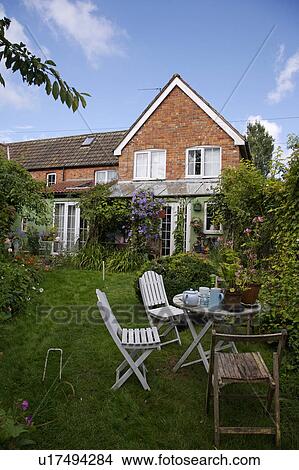 Small suburban garden with simple furniture on lawn in summer. View Large Photo Image Picture - Small suburban garden with simple furniture on lawn in summer.. Fotosearch