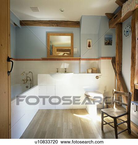 Small wooden chair in pastel blue and white country bathroom with wooden flooring View Large Photo Image Stock Image - Small wooden chair in pastel blue and white country bathroom with wooden flooring. Fotosearch