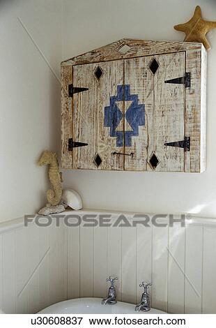 Smalll wooden cupboard above tongue+groove panelling in white bathroom View Large Photo Image Stock Photo - Smalll wooden cupboard above tongue+groove panelling in white bathroom. Fotosearch