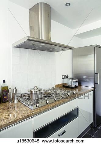 Stainless steel extractor above hob in beige granite worktop View Large Photo Image Stock Photography - Stainless steel extractor above hob in beige granite worktop. Fotosearch