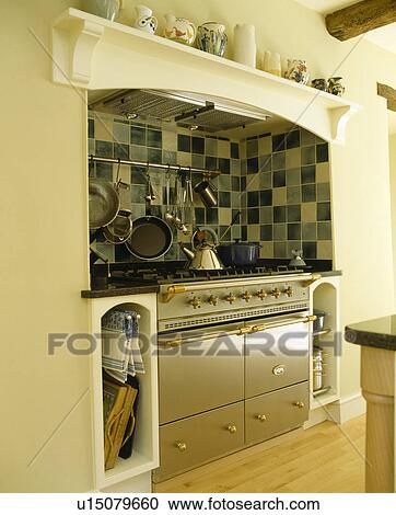 Stock Image - Stainless steel range oven in country kitchen. Fotosearch