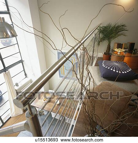 Stock Image - Steel bannisters on mezzanine floor above dining area in modern loft conversion. Fotosearch