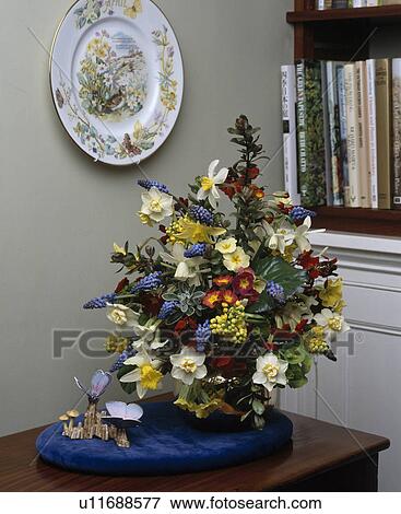 Stock Photo - Still-Life of daffodils with primroses and grape-hyacinths in formal spring floral arrangement. Fotosearch