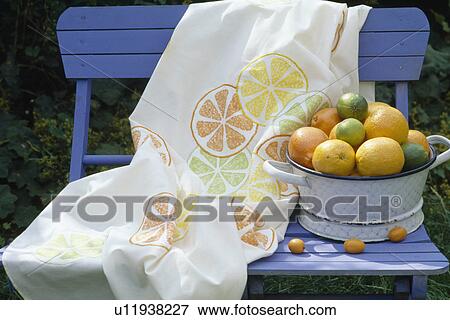 Still-Life of fabric stencilled with orange segments on blue wooden bench with lemons and limes in enamel dish View Large Photo Image Stock Photo - Still-Life of fabric stencilled with orange segments on blue wooden bench with lemons and limes in enamel dish. Fotosearch