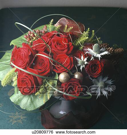 Stock Photograph - Still-Life of red roses and eryngium in formal flower arrangement. Fotosearch