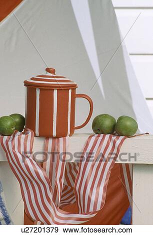 Stock Photo - Still-Life of red+white striped enamel cup with striped fabric. Fotosearch