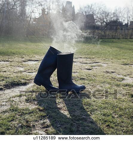 Still-Life of smoke coming out of pair of Wellington boots View Large Photo Image Stock Photo - Still-Life of smoke coming out of pair of Wellington boots. Fotosearch