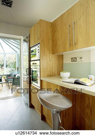 Stool at worktop in modern kitchen with pale wood units View Large Photo Image Picture - Stool at worktop in modern kitchen with pale wood units . Fotosearch