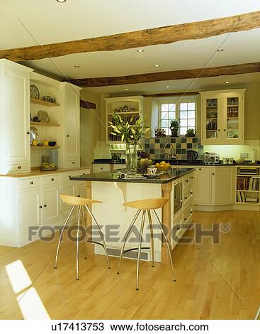 Stools at island unit in modern country kitchen with wooden flooring View Large Photo Image Stock Image - Stools at island unit in modern country kitchen with wooden flooring. Fotosearch