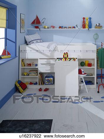 Storage shelves below white platform bed in child's pastel blue bedroom with painted blue footprints on white flooring View Large Photo Image Stock Image - Storage shelves below white platform bed in child's pastel blue bedroom with painted blue footprints on white flooring. Fotosearch