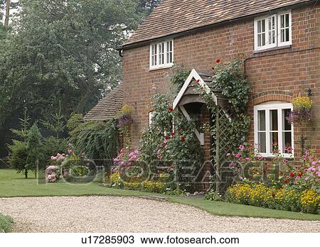 Summer garden border in front of Victorian brick cottage with wooden porch View Large Photo Image Stock Image - Summer garden border in front of Victorian brick cottage with wooden porch. Fotosearch