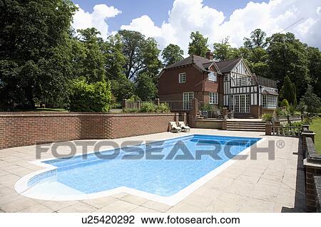 Stock Image - Swimming pool in garden of country house. Fotosearch