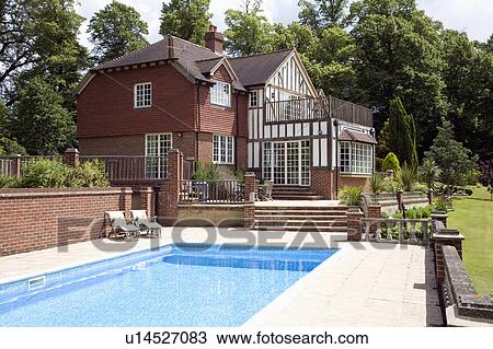 Swimming pool in large garden of newbuild traditional house in the country View Large Photo Image Stock Image - Swimming pool in large garden of newbuild traditional house in the country. Fotosearch