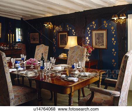 Table set for dinner in traditional green dining room with gold stencilling on walls View Large Photo Image Stock Photo - Table set for dinner in traditional green dining room with gold stencilling on walls. Fotosearch