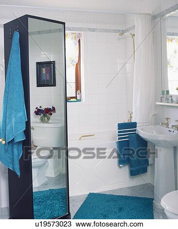 Tall mirrored cupboard in small white bathroom View Large Photo Image Stock Image - Tall mirrored cupboard in small white bathroom. Fotosearch
