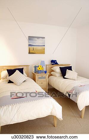 Throws with boat motif on single beds in cream duvets in modern white bedroom View Large Photo Image Stock Image - Throws with boat motif on single beds in cream duvets in modern white bedroom. Fotosearch