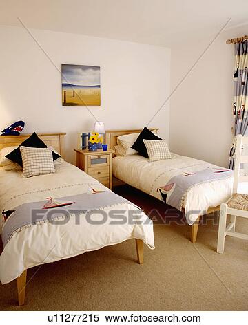 Throws with boat motif on single beds in cream duvets in modern white bedroom with cream carpet View Large Photo Image Stock Photography - Throws with boat motif on single beds in cream duvets in modern white bedroom with cream carpet. Fotosearch