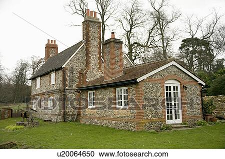 Stock Image - Traditional 18th century flint cottage with single storey extension . Fotosearch
