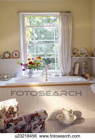 Stock Photograph - Traditional white bathroom with window looking onto garden.. Fotosearch