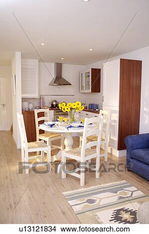 Traditional white chairs and circular table in modern kitchen dining room with wooden flooring View Large Photo Image Picture - Traditional white chairs and circular table in modern kitchen dining room with wooden flooring. Fotosearch