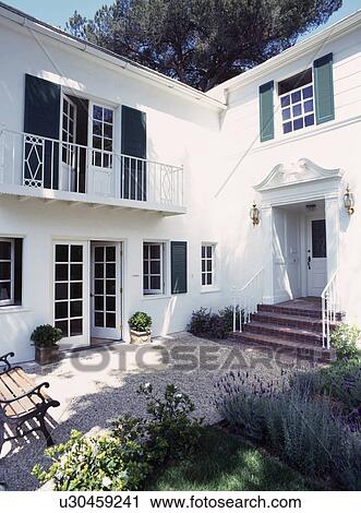 Traditional white house with balcony and scented lavender in border of cobbled courtyard View Large Photo Image Stock Image - Traditional white house with balcony and scented lavender in border of cobbled courtyard. Fotosearch