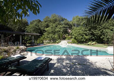 Picture - Turquoise swimming pool in garden of house on Mallorca. Fotosearch