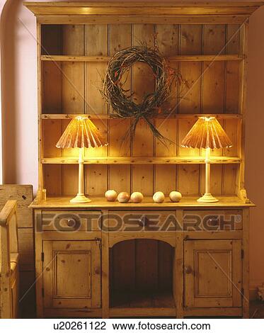 Two lighted lamps on old pine dresser with rustic wreath View Large Photo Image Stock Image - Two lighted lamps on old pine dresser with rustic wreath. Fotosearch
