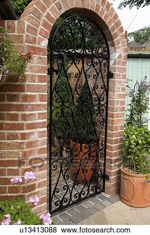 Pictures of View of closed wrought iron gate in brick arch from within ...