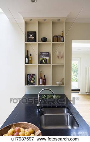 Underset sink in granite worktop in modern kitchen with beige storage shelves View Large Photo Image Stock Photo - Underset sink in granite worktop in modern kitchen with beige storage shelves. Fotosearch
