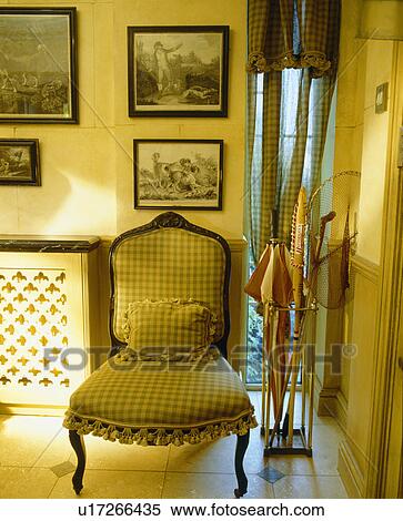 Stock Photography - Upholstered chair in traditional cream hall. Fotosearch