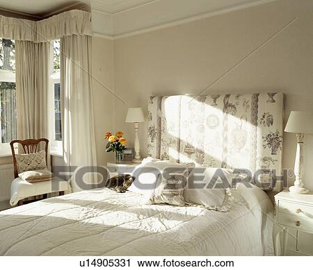 Upholstered floral headboard on bed in cream traditional bedroom View Large Photo Image Stock Image - Upholstered floral headboard on bed in cream traditional bedroom. Fotosearch