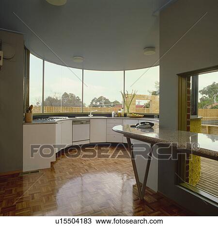 Varnished wood-block flooring in modern kitchen with large windows above curved fitted units View Large Photo Image Stock Image - Varnished wood-block flooring in modern kitchen with large windows above curved fitted units. Fotosearch