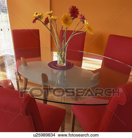 Vase of gerberas on glass table orange dining room with red upholstered chairs View Large Photo Image Picture - Vase of gerberas on glass table orange dining room with red upholstered chairs. Fotosearch