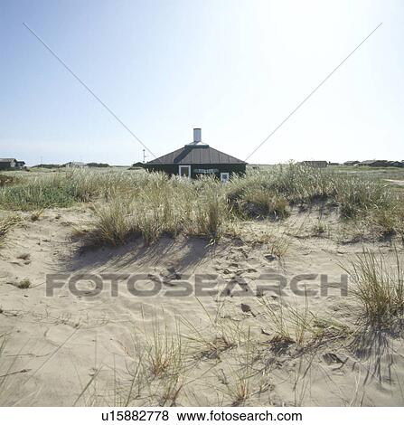 View across sand dunes of small single storey house View Large Photo Image Stock Photo - View across sand dunes of small single storey house. Fotosearch