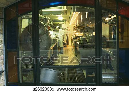 Stock Photography - View through window of chefs in kitchen of modern restaurant. Fotosearch