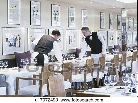 Waiters setting tables at modern London restaurant designed by Terence Conran View Large Photo Image Stock Image - Waiters setting tables at modern London restaurant designed by Terence Conran. Fotosearch