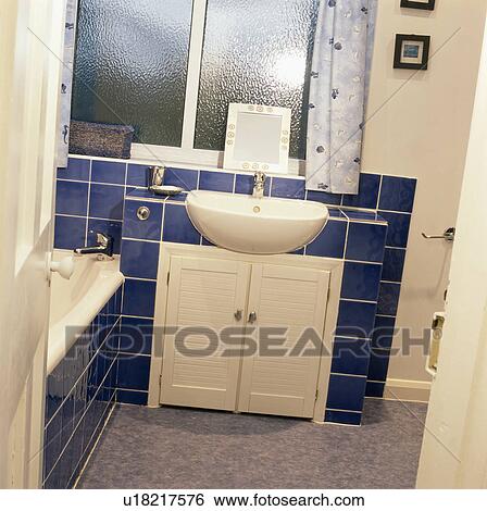 Wall-mounted basin in economy-styled bathroom with blue wall tiles View Large Photo Image Stock Photograph - Wall-mounted basin in economy-styled bathroom with blue wall tiles. Fotosearch