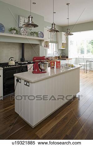 Stock Photography - Walnut flooring in grey-blue kitchen with quartz-laminate worktop on cream island unit. Fotosearch