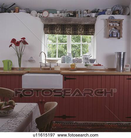 White Belfast sink below window in white cottage kitchen with fitted pink units View Large Photo Image Stock Photo - White Belfast sink below window in white cottage kitchen with fitted pink units. Fotosearch