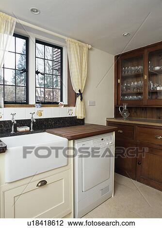 White Belfast sink beside concealed dishwasher in country kitchen View Large Photo Image Stock Image - White Belfast sink beside concealed dishwasher in country kitchen. Fotosearch
