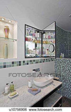 White bowl-style basin on Carrera marble-topped vanity unit below recessed wall cabinet with mirrored door View Large Photo Image Stock Photograph - White bowl-style basin on Carrera marble-topped vanity unit below recessed wall cabinet with mirrored door. Fotosearch