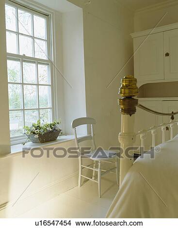 White chair beside window in white country bedroom View Large Photo Image Picture - White chair beside window in white country bedroom. Fotosearch
