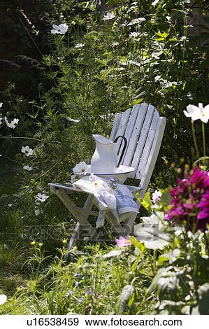 White chair in garden surrounded by mature summer plants. View Large Photo Image Stock Photo - White chair in garden surrounded by mature summer plants.. Fotosearch