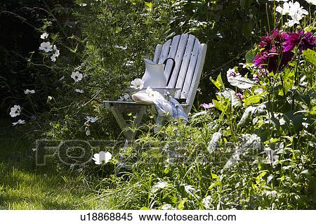 White chair in garden surrounded by mature summer plants. View Large Photo Image Stock Photography - White chair in garden surrounded by mature summer plants.. Fotosearch