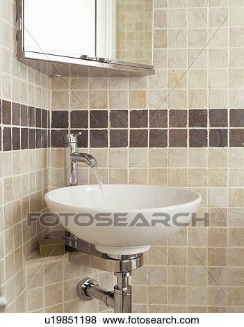 White circular basin in modern beige tiled bathroom View Large Photo Image Stock Photo - White circular basin in modern beige tiled bathroom. Fotosearch