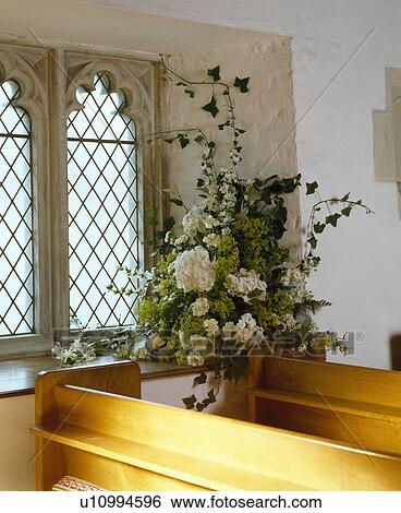 Stock Photograph - White floral arrangement in church. Fotosearch