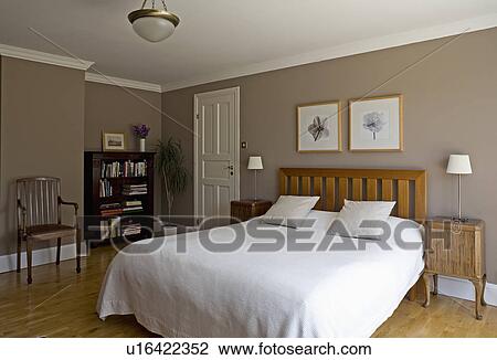 Stock Image - White linen on bed in modern beige bedroom. Fotosearch