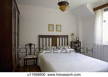 Stock Photography Of White Linen On Bed In Small Uncluttered Stock Photography White Linen On Bed In Small Uncluttered Bedroom Fotosearch Search