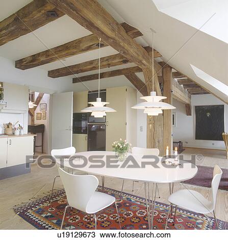 White pendant lamps above modern oval white table and chairs in open-plan country ding room with beamed ceiling View Large Photo Image Stock Image - White pendant lamps above modern oval white table and chairs in open-plan country ding room with beamed ceiling. Fotosearch